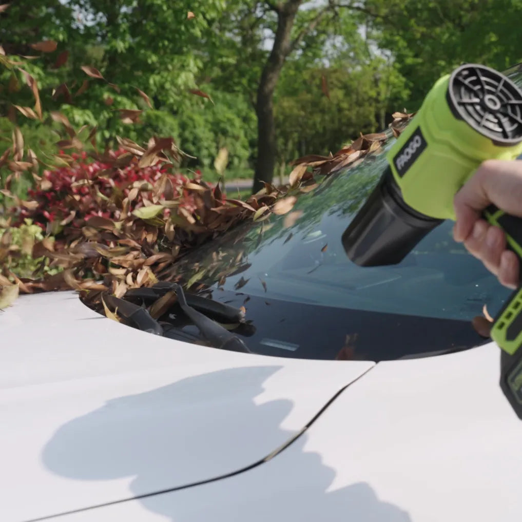 FAOGO cordless car dryer blowing autumn leaves off a windshield. Portable high-speed blower for vehicle exterior cleaning.