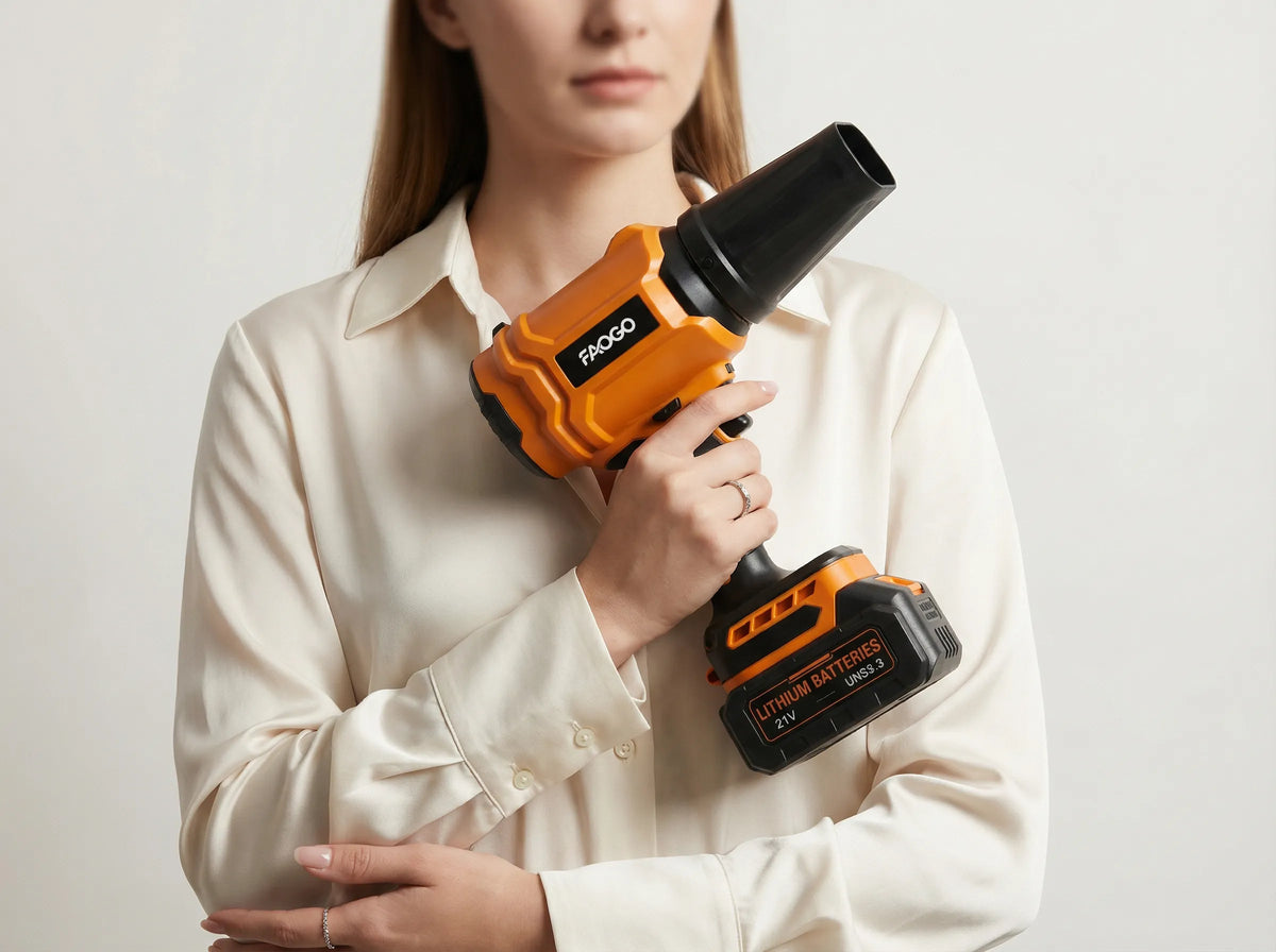 Woman easily holding an orange FAOGO 21V cordless air duster, highlighting its lightweight design.